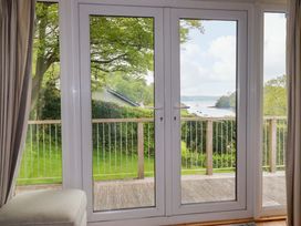 Sliding doors leading to a balcony with a view of water at The Meadow in Feock near Carnon Downs