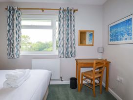 A bedroom with a bed and desk at The Meadow in Feock near Carnon Downs