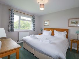 A bedroom with two beds and a window at The Meadow in Feock near Carnon Downs