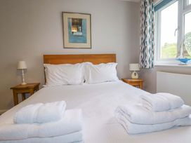 A bedroom with a bed and bedside tables at The Meadow in Feock near Carnon Downs