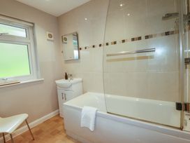 A bathroom with a bathtub and washbasin at The Meadow in Feock near Carnon Downs