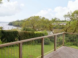 A deck overlooking water with trees and boats at The Meadow in Feock near Carnon Downs