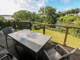 An outdoor patio with a table and chairs overlooking a water view at The Meadow in Feock near Carnon Downs