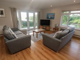 A living room with a television and two sofas at The Meadow in Feock near Carnon Downs