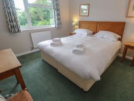 A bedroom with a bed and desk at The Meadow in Feock near Carnon Downs