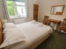 A bedroom with a bed and table at The Meadow in Feock near Carnon Downs