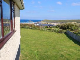A view of the sea and houses from a garden at Pentreath in Crantock