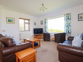 A living room with a television and sofa at Pentreath in Crantock