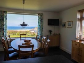 A dining room with a round table and sea view at Pentreath in Crantock