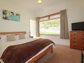 A bedroom with a bed and television at Pentreath in Crantock