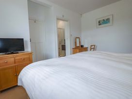 A bedroom with a bed and television at Pentreath in Crantock