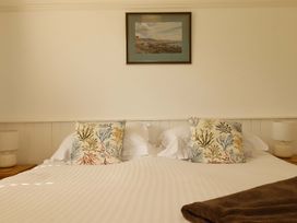 A bedroom with a bed and decorative pillows at Pentreath in Crantock