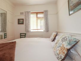 A bedroom with a bed and window at Pentreath in Crantock