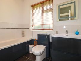 A bathroom with a bathtub, toilet, and sink at Pentreath in Crantock
