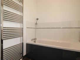 A bathroom with a bathtub and towel radiator at Pentreath Crantock