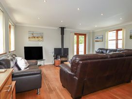 A living room with a television and a wood stove at Carpe Diem in Crantock