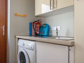 A laundry room with a washing machine and sink at Carpe Diem in Crantock