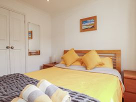A bedroom with a bed and framed painting at Carpe Diem in Crantock