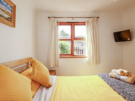 A bedroom with a bed and window at Carpe Diem in Crantock