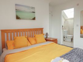 A bedroom with a bed and adjoining bathroom at Carpe Diem in Crantock