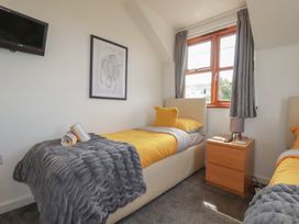A bedroom with two beds and a nightstand at Carpe Diem in Crantock