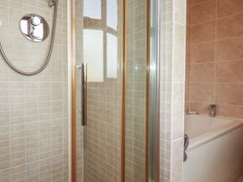 A bathroom with a shower and bathtub at Carpe Diem in Crantock