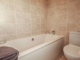 A bathroom with a bathtub and a toilet at Carpe Diem in Crantock