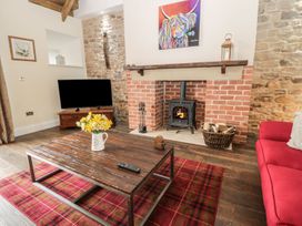 A living room with a fireplace and sofa at The Turnip Barn