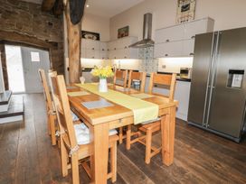 A kitchen with a dining table and refrigerator at The Turnip Barn