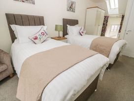 A bedroom with two beds and a table at The Turnip Barn in 