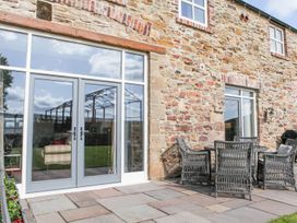 An outdoor area with double doors and furniture at The Turnip Barn in 