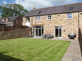 A garden with stone wall and patio furniture at The Turnip Barn in 
