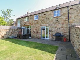 A garden with a patio and table at The Turnip Barn in Durham