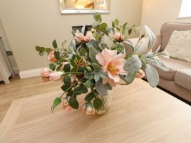 A flower arrangement in a vase on a table at Tan Y Goeden in Morfa Nefyn