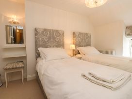 A bedroom with twin beds and a mirror at Tan Y Goeden in Morfa Nefyn