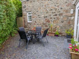 A garden with a table and chairs at Tan Y Goeden in Morfa Nefyn