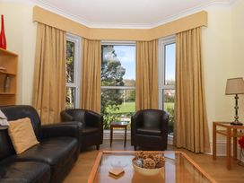 A living room with a sofa, chairs, and a coffee table at Avenue Park Villa in Torquay