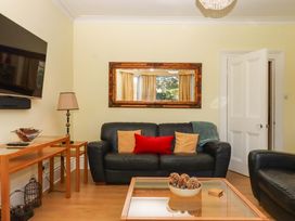 A living room with a sofa and a television at Avenue Park Villa in Torquay