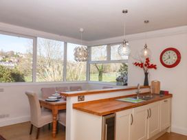 A kitchen with a dining area and large windows at Avenue Park Villa in Torquay