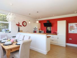 A kitchen with dining table and chairs at Avenue Park Villa, Torquay