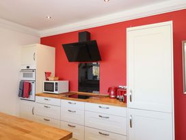 A kitchen with appliances and cabinets at Avenue Park Villa in Torquay