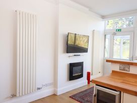 A kitchen with a TV mounted on the wall at Avenue Park Villa in Torquay