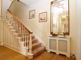 A hallway with a staircase and mirror at Avenue Park Villa in Torquay