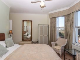 A bedroom with a bed and chair at Avenue Park Villa in Torquay