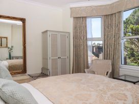 A bedroom with a bed and mirror at Avenue Park Villa in Torquay