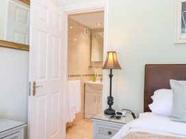 A bedroom with a bed and doorway to an adjoining bathroom at Avenue Park Villa in Torquay