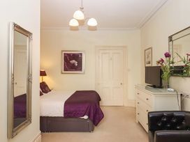 A bedroom with a bed and television at Avenue Park Villa in Torquay