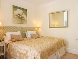 A bedroom with a bed and mirror at Avenue Park Villa in Torquay
