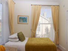 A bedroom with a bed and painting at Avenue Park Villa in Torquay