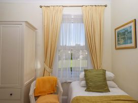 A bedroom with a bed and armchair at Avenue Park Villa in Torquay